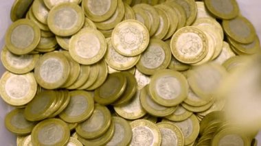 Yukarıdan para yığınına para atmak.