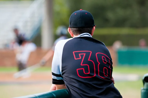 Baseballový hráč sledovat hru z krytu — Stock fotografie