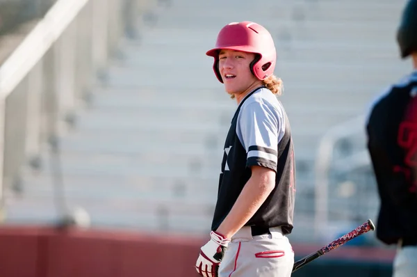 High school baseball player with long hair batting. — Stock Photo, Image