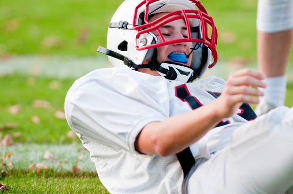 Football americano ragazzo a terra — Foto Stock