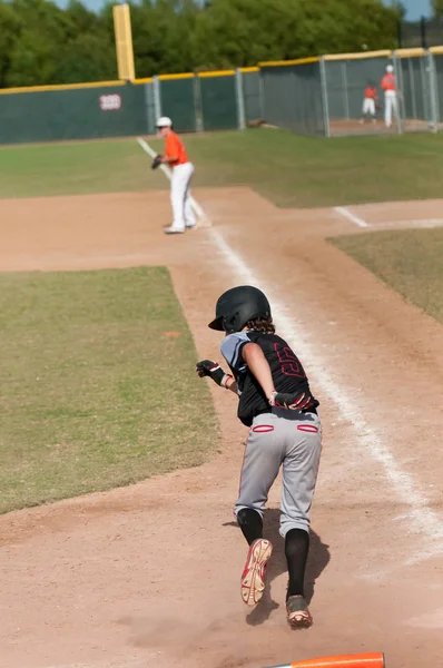 Kid basebollspelare tar första bas — Stockfoto