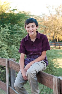 Genç yakışıklı bir çit açık oturan profil portresi