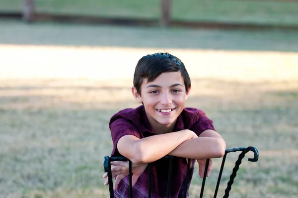 Retrato de lindo niño sentado en una silla al aire libre . —  Fotos de Stock