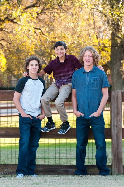 Tres chicos guapos posando al aire libre Imagen de stock