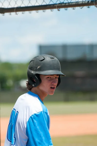 Serious high school baseball player in dugout — Stock Photo, Image