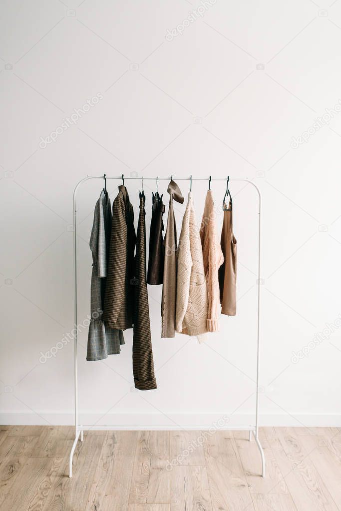 Rack with capsule clothes in beige colors