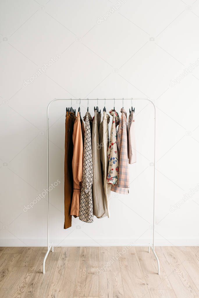 Rack with capsule clothes in beige colors