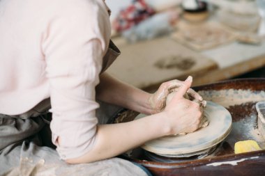 Çömlekçi çarkında fincan yapan kız..