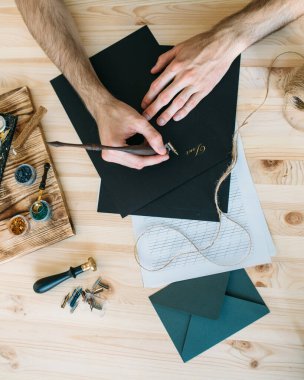 Siyah kağıda yazı yazan adam.