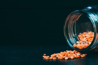 Bezelye Groats koyu bir arka plan ve tezgahta bir kutudan yayılmış.