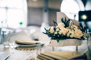 Küçük bir piyanoda notalar ve çiçeklerle süslenmiş bir masa.