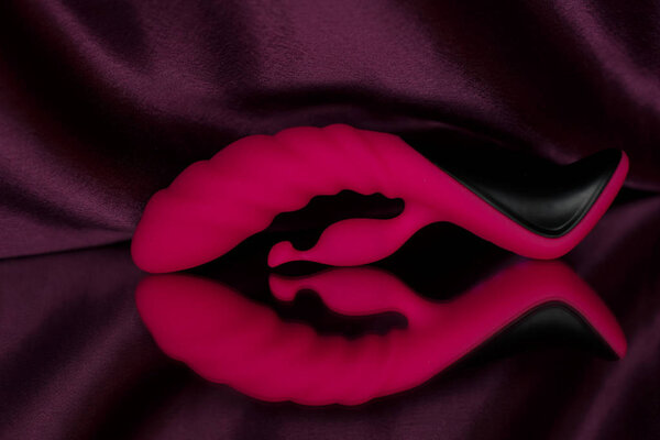 Futuristic vibrator with a process for clitoral stimulation. Photo sex toys on the mirror.