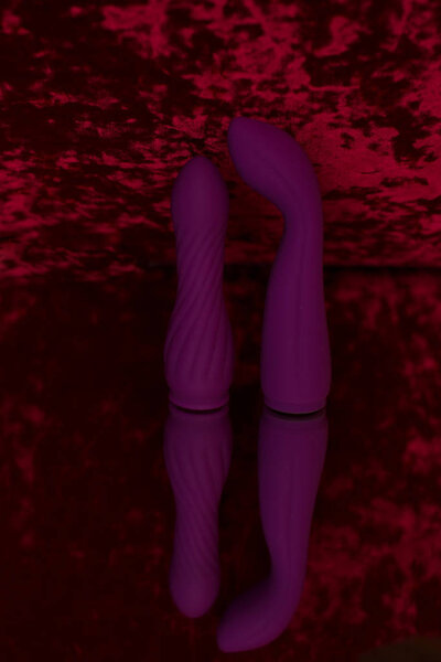 Purple futuristic vibrator with a process for clitoral stimulation. Photo sex toys on the mirror.