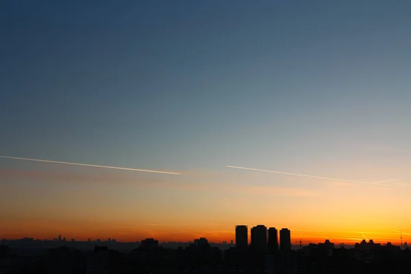 Şehir binalarının silueti güzel bir günbatımının arka planında — Stok fotoğraf