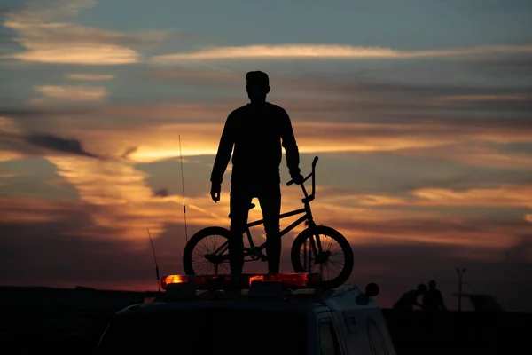 Radfahrer bei Sonnenuntergang Hintergrund Skispringen Wettbewerbe — Stockfoto