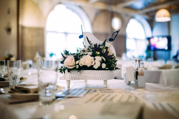 Mesa decorada com notas e flores em um pequeno piano — Fotografia de Stock