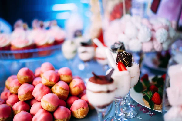 Schön dekorierter Tisch mit verschiedenen Kuchen und Süßigkeiten. Hausgemachtes Eis mit Marmelade Schokolade und Minze. Süßigkeiten zum Kindergeburtstag — Stockfoto