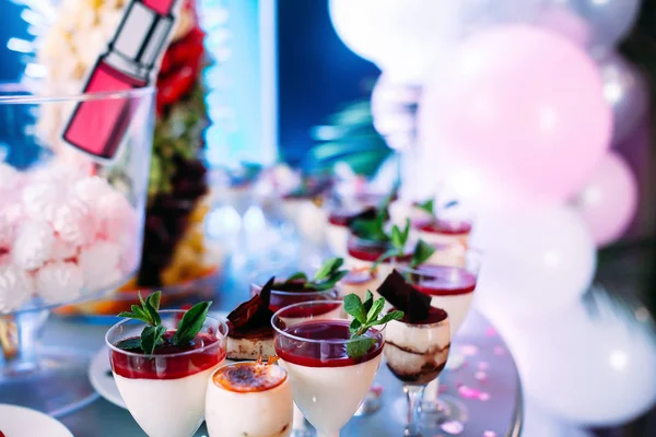 Schön dekorierter Tisch mit verschiedenen Kuchen und Süßigkeiten. Hausgemachtes Eis mit Marmelade Schokolade und Minze. Süßigkeiten zum Kindergeburtstag — Stockfoto