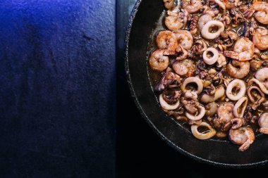 Kızartma tavası, deniz ürünleri, ahtapot, kalamar halkaları, karides karışımı. Soya soslu deniz ürünleri. Tavada yemek pişirmek.