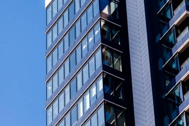 Gökyüzüne bakan büyük cam pencereli koyu mavi bir bina. Gökdelen kapanıyor. İş oluşturma