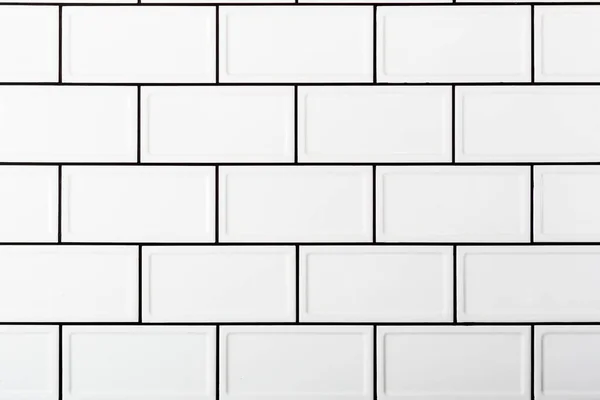 White tile texture with contrasting black seams. Tiles in the kitchen.