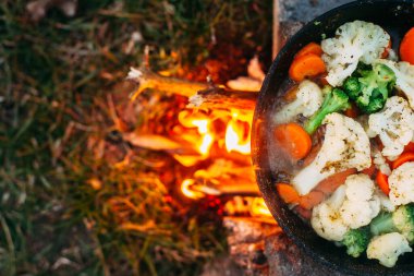 Karnabahar, brokoli ve tavada havuç. Açık ateşte yemek pişirmek. Açık hava yemekleri. Izgara sebze. Kamp gezisinde yemek.