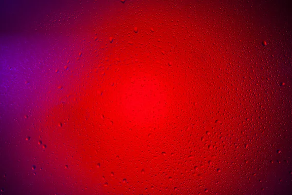 赤いネオンライトのガラスに水の滴 色のついたライトを背景にガラスに雨 背景のアブストラクト写真 — ストック写真