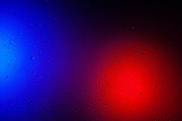 赤青ネオンライトでガラス上の水の滴 2つの色のライトの背景にガラス上の雨 背景のアブストラクト写真 — ストック写真