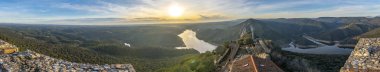 Extremadura ve Tietar nehri engebeli araziyi geçerek bir lagün oluşturuyor. İnanılmaz Monfrage Ulusal Parkı. Renklerle ve bulutlu gökyüzünün su yansımalarıyla dolu. Güzel bir yolculuk yeri.