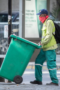 Şehir: Santiago Ülke: 2 Mayıs 2020 Coronavirus hastalığı enfeksiyonu sırasında CVID-19 enfeksiyonu sırasında Providencia caddelerini temizlerken endişeli gerçek göçmen temizlik işçisi
