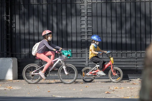 City: Santiago Country: Chile 2nd May 2020 Family protected with masks and riding bikes in Providencia streets during the coronavirus infection disease COVID-19