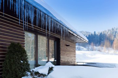 güzel kış manzarası, çatı buz sarkıtları ile ev