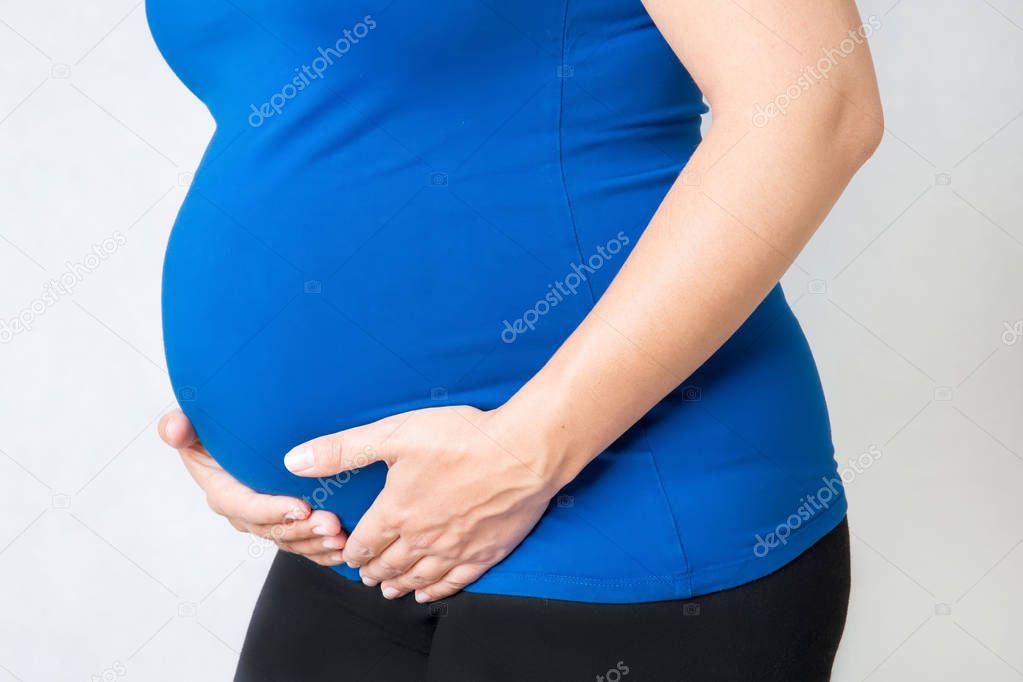 pregnant woman holding hands on her belly