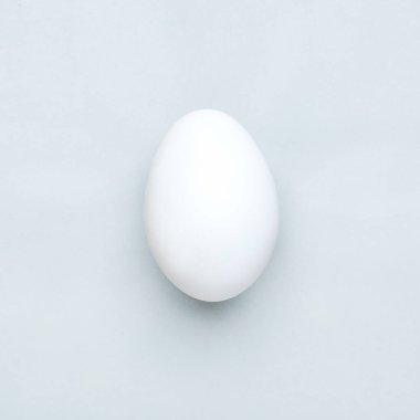 Gri arka planda en az beyaz paskalya yumurtası, düz.