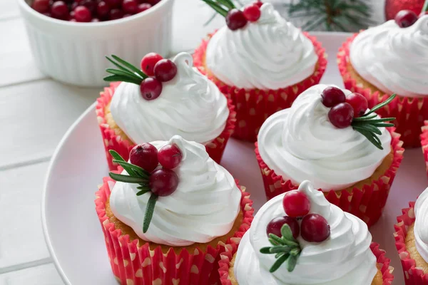 Christmas cupcakes with vanilla frosting, cranberries and rosemary — Stock Photo, Image