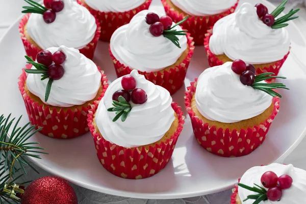 Christmas cupcakes with vanilla frosting, cranberries and rosemary — Stock Photo, Image