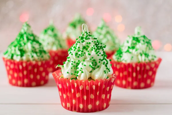 Cupcakes de Natal com forma de árvore de Natal, sparkler e luzes no fundo — Fotografia de Stock