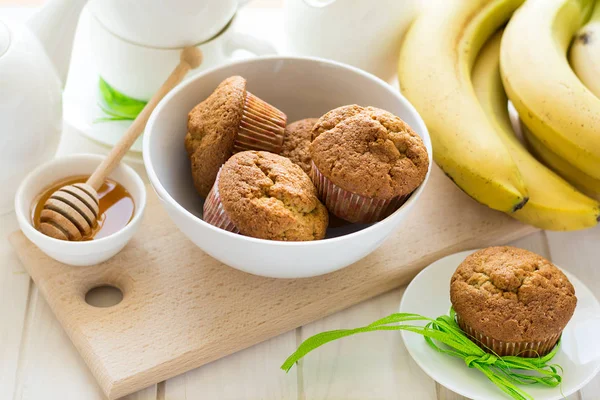 Tea time: homemade banana muffins, honey, bananas and tea settings — Stock Photo, Image