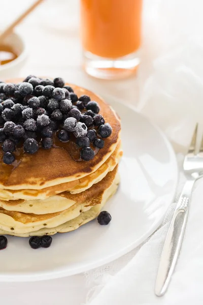 Stapel Pfannkuchen mit gefrorenen Blaubeeren und Honig — Stockfoto