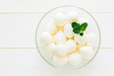 Küçük topları mozzarella cam kase taze nane yaprakları dekore edilmiştir.