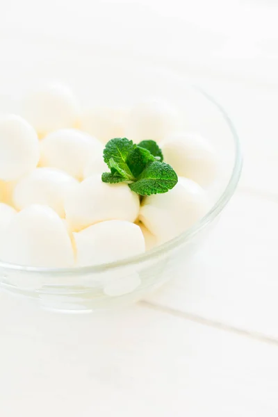 Pequenas bolas de mussarela em tigela de vidro decorado folhas de hortelã fresca — Fotografia de Stock