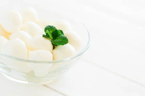 Small balls of mozzarella in glass bowl decorated fresh mint leaves — Stock Photo, Image