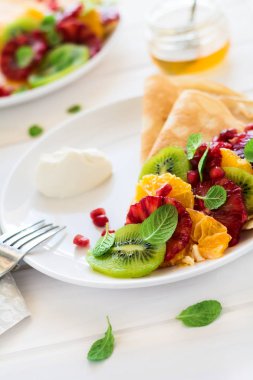 Taze kivi, portakal, Sicilya turuncu, tatlım, krem ve nane yaprakları ile ince krep