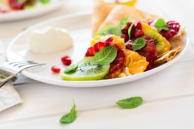 Taze kivi, portakal, Sicilya turuncu, tatlım, krem ve nane yaprakları ile ince krep