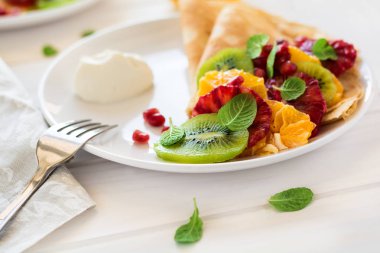 Taze kivi, portakal, Sicilya turuncu, tatlım, krem ve nane yaprakları ile ince krep