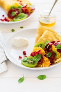 Taze kivi, portakal, Sicilya turuncu, tatlım, krem ve nane yaprakları ile ince krep