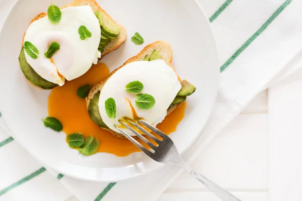 Vegetarisk frukost: avocado toast med pocherat ägg, apelsinjuice, yoghurt och sylt — Stockfoto