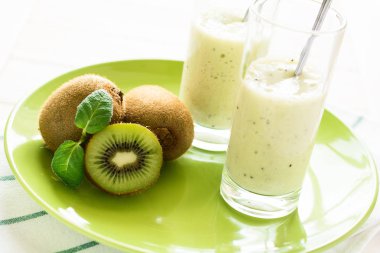 Nane yaprakları iki bardak taze kivi meyve ve muz smoothie ile dekore edilmiş
