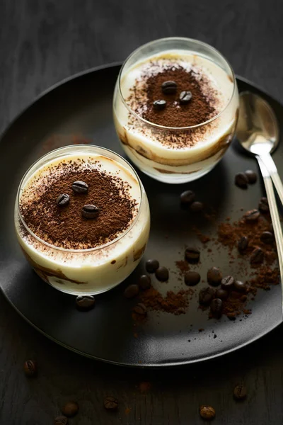 Традиционный итальянский десерт тирамису украшенный какао, кофейные зерна и мятные листья — стоковое фото