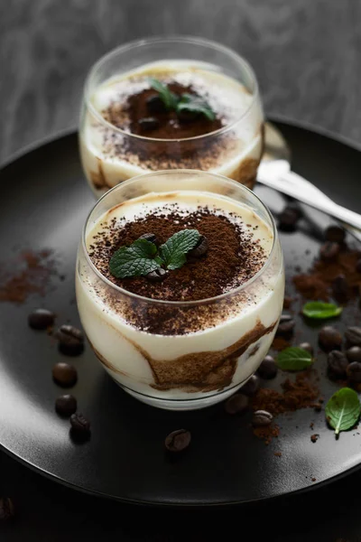 Традиционный итальянский десерт тирамису украшенный какао, кофейные зерна и мятные листья — стоковое фото